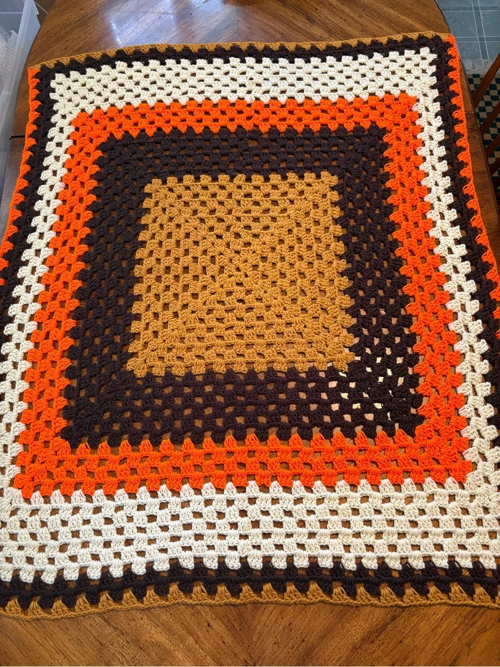 handmade rectangular crochet blanket features a classic square-in-a-square motif